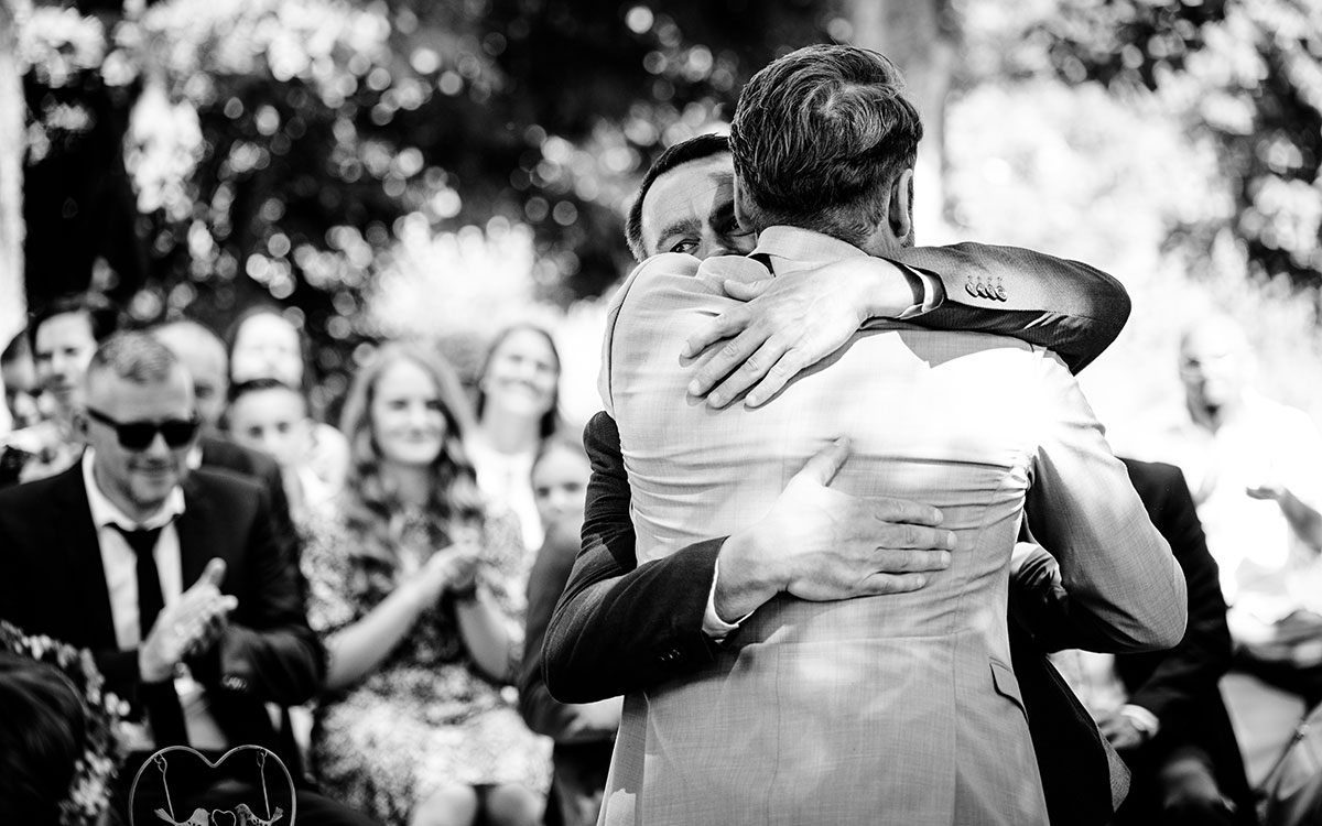 Trauzeuge und Bräutigam umarmen sich