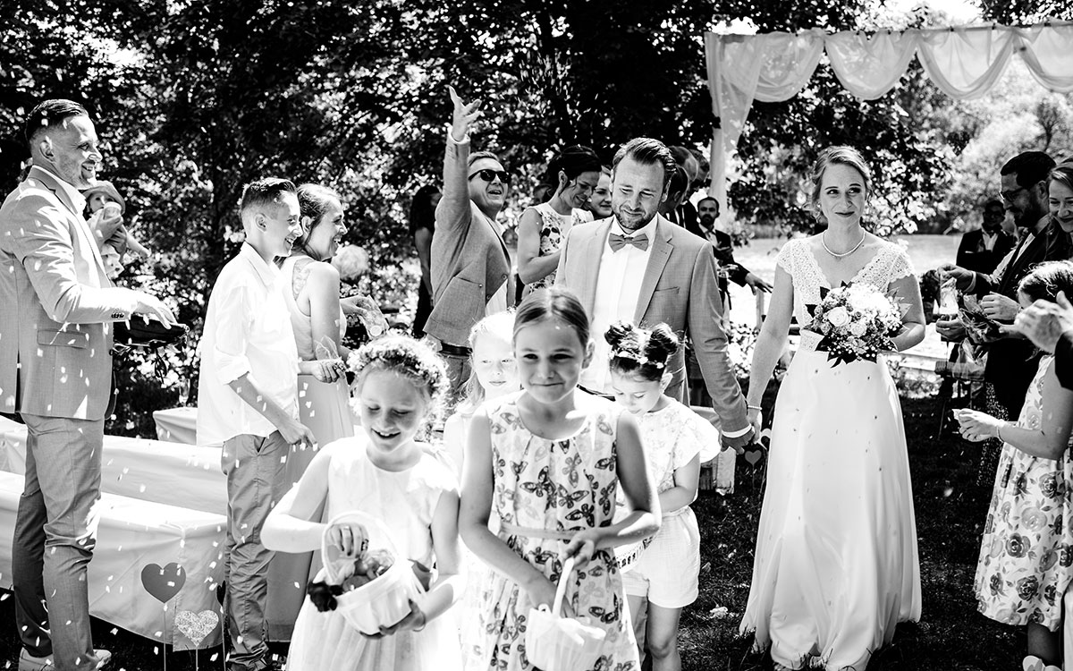 Hochzeitspaar und Blumenmädchen beim Auszug