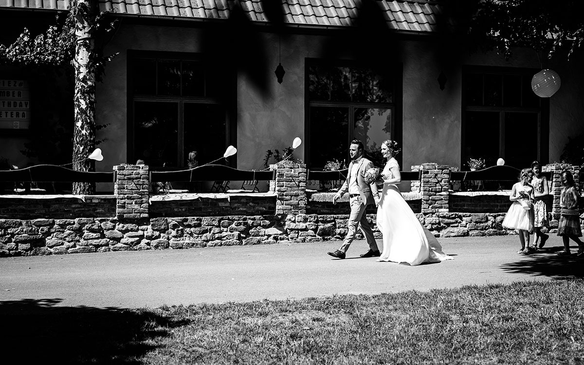 Braut und Bräutigam spazieren zur Hochzeitsfeier