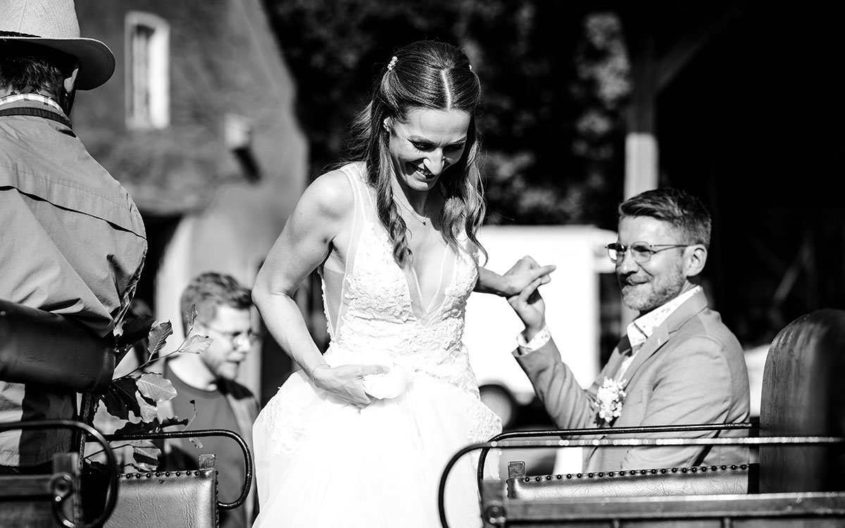 Hochzeitspaar beim Einsteigen in die Kutsche
