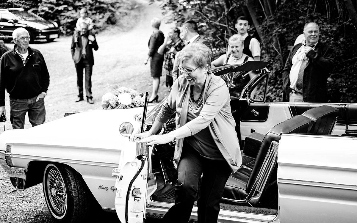 Hochzeitsgäste mit dem Hochzeitsauto