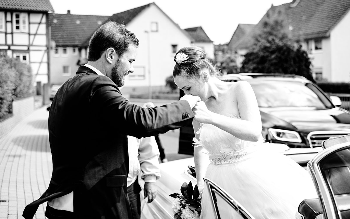 Braut beim Aussteigen aus dem Hochzeitsauto