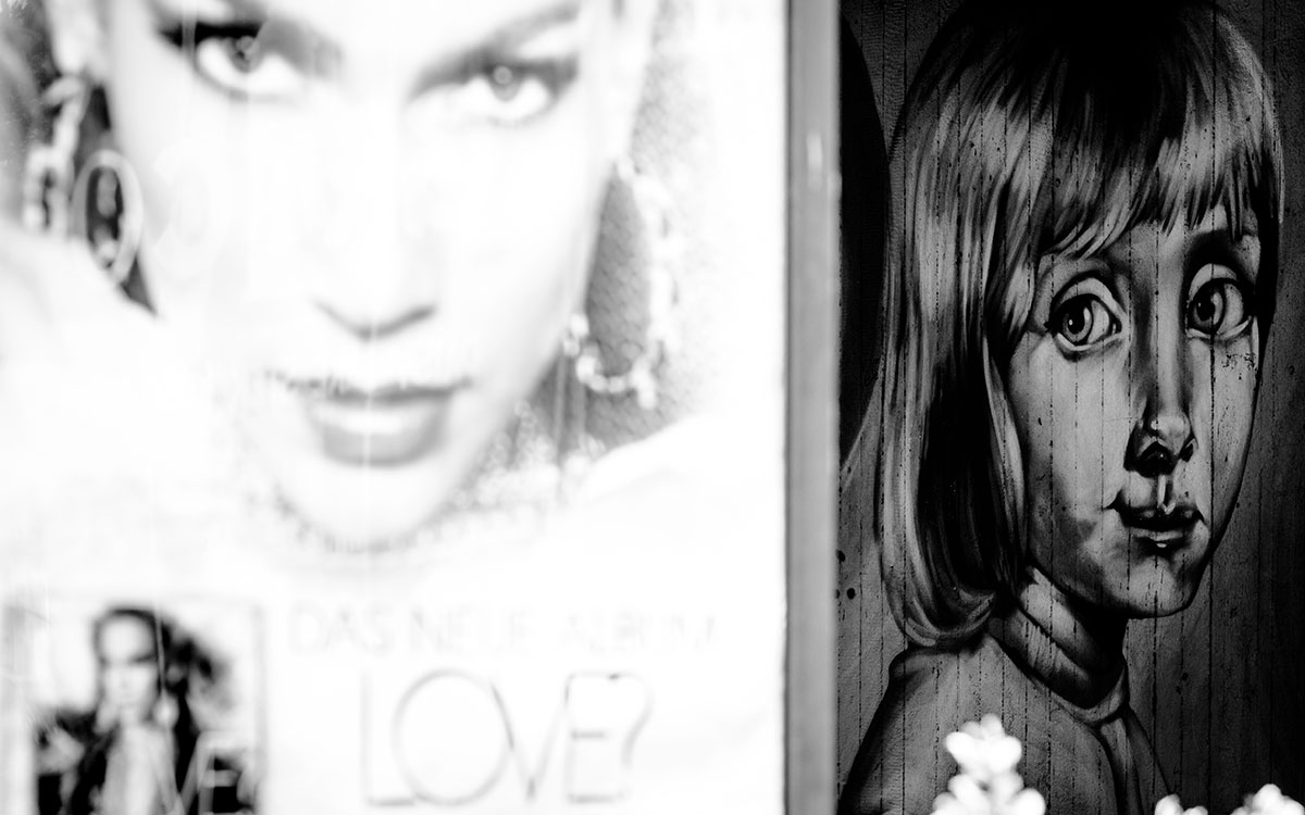 Plakatwerbung neben Graffiti