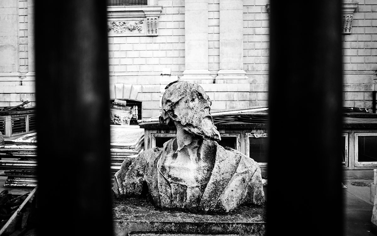 Alte Statue hinter Gitterstäben