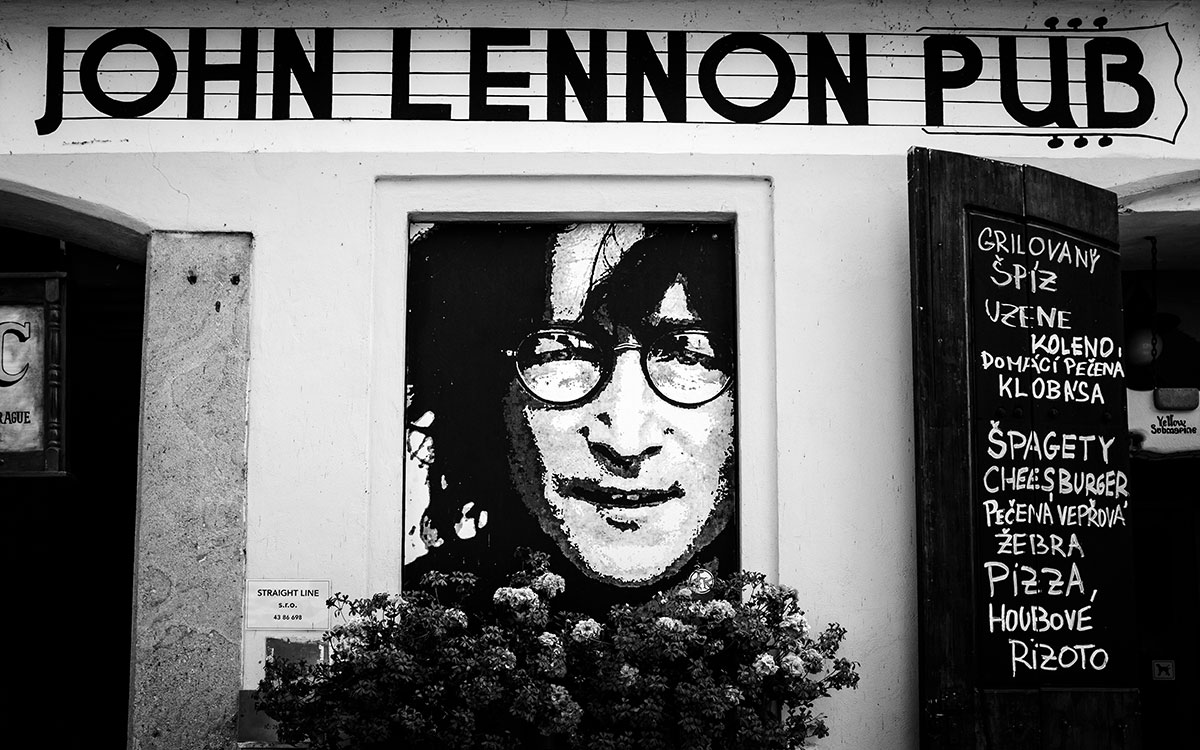 Touristen, Musiker und Künstler an der John Lennon Wall